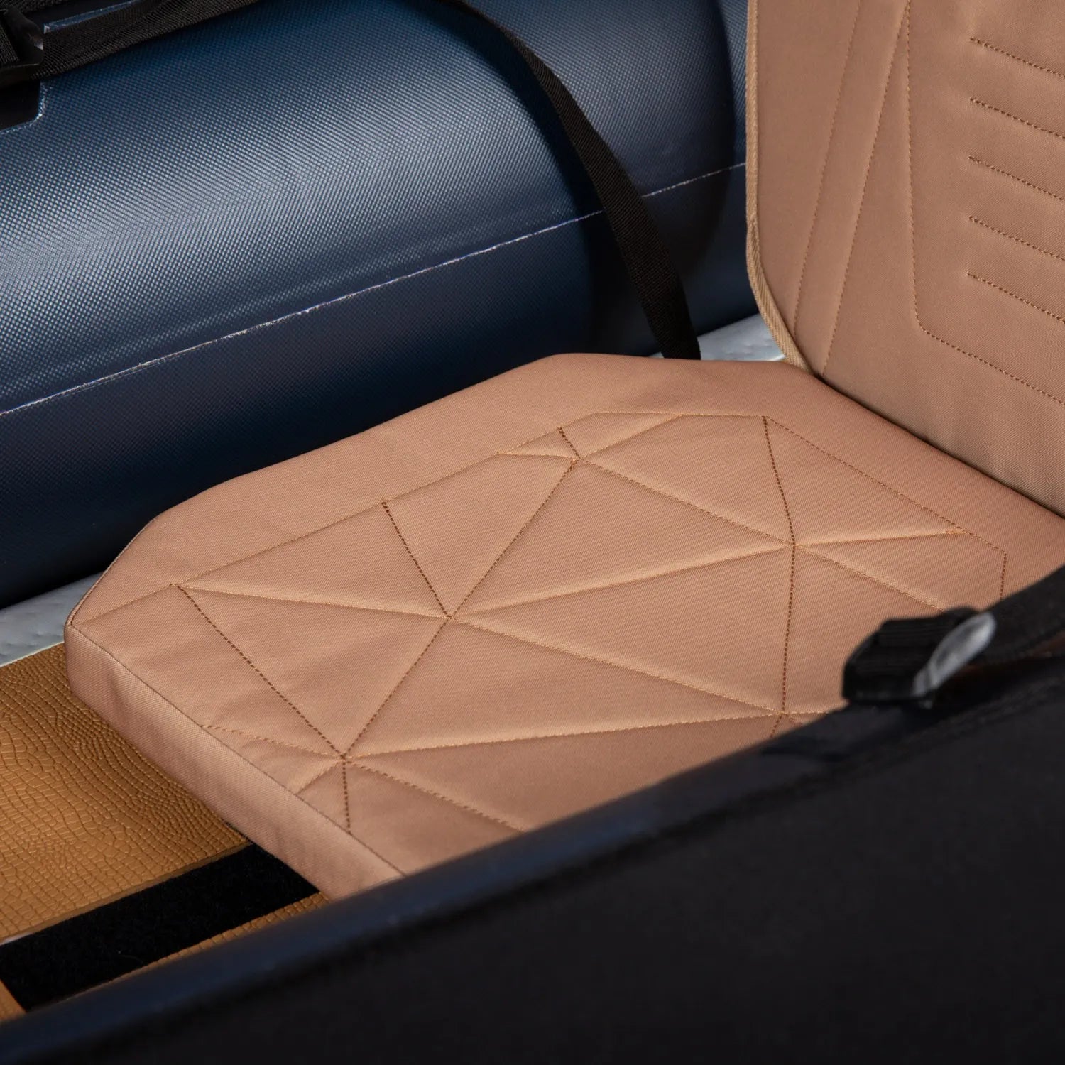 Close-up of a brown quilted car seat cover with geometric pattern